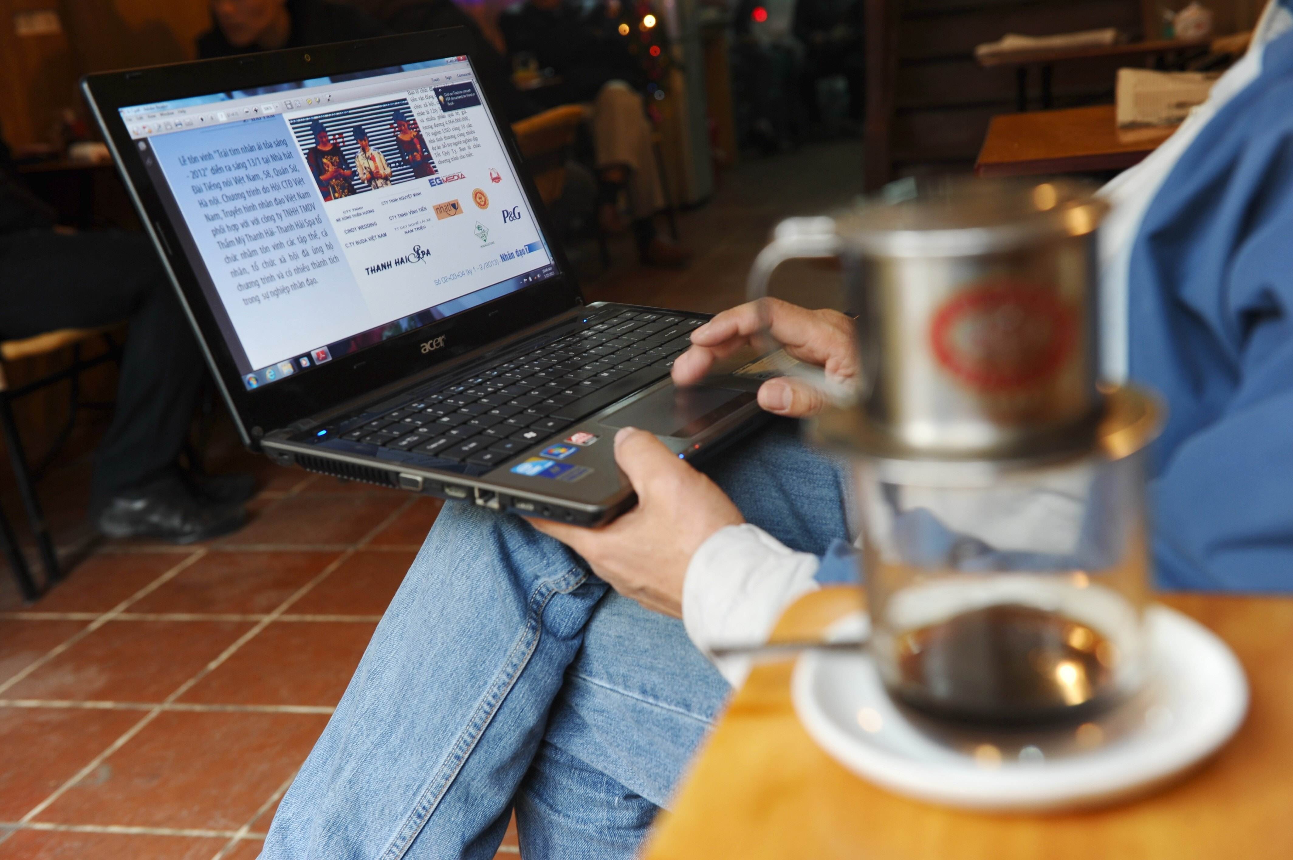 A man reads the news on his laptop in a coffee shop in Hanoi. About two thirds of Vietnam’s 97 million people are online and authorities are increasingly fixated on gauging public sentiment online. Photo: AFP