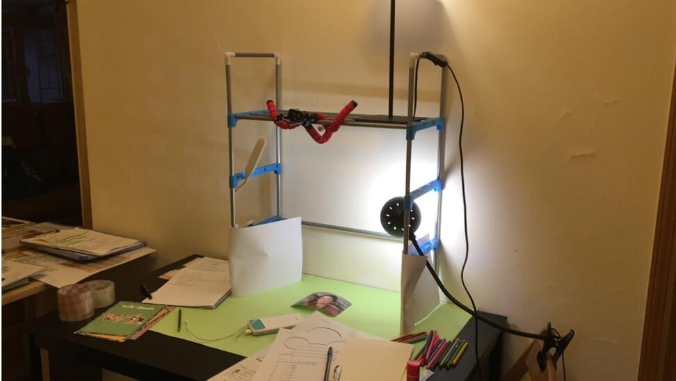 Wong’s makeshift work station for teaching classes online, constructed from a shoe rack and with a phone holder attached.