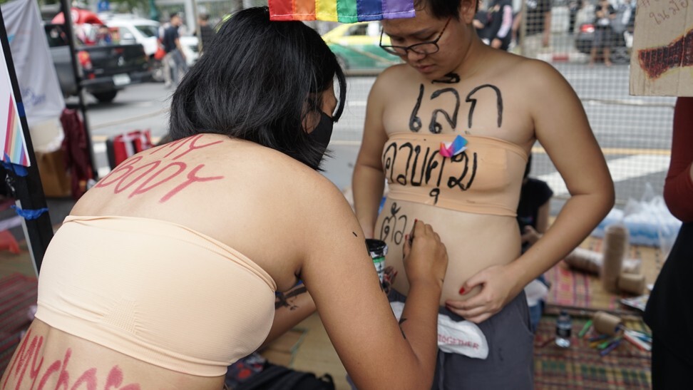 A women's rights activist paints “Stop controlling my body” on a fellow protester at a rally in Bangkok on September 19, 2020. Photo: Handout