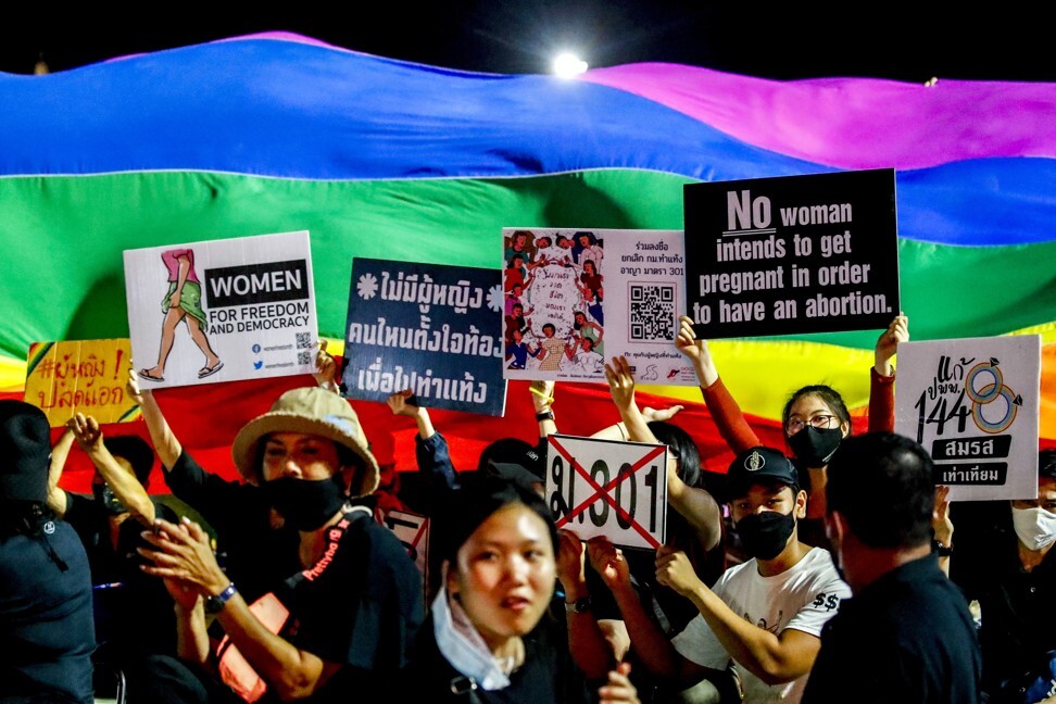 LGBTQ and women’s rights advocates hold up signs next to a rainbow flag on September 19, 2020. Photo: EPA-EFE