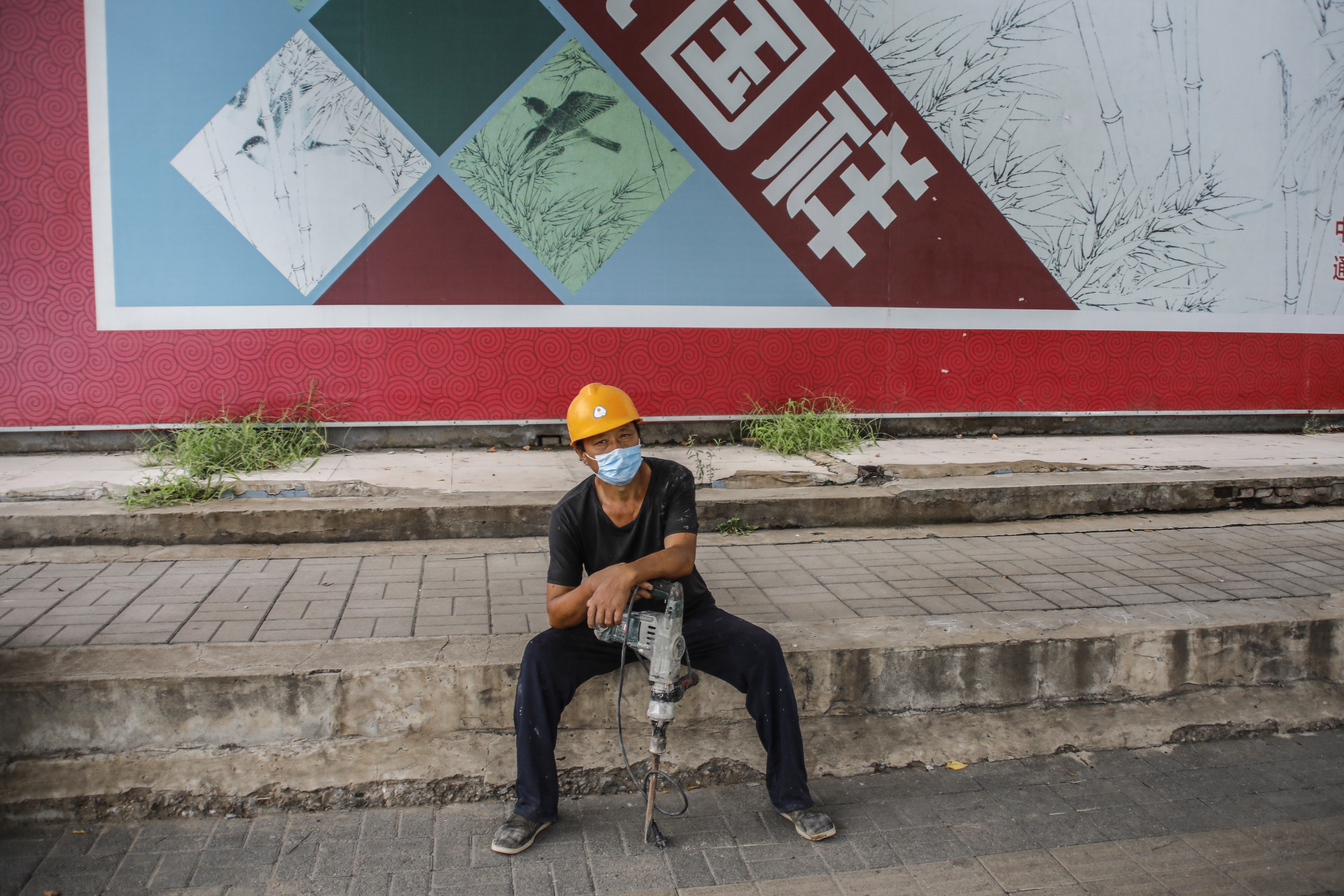 A migrant labourer waits for work on the street in Beijing on August 17. The prospect of a protracted recession and a jobless recovery thereafter could make life especially tough for firms and workers not integrated into the digital world. Photo: EPA
