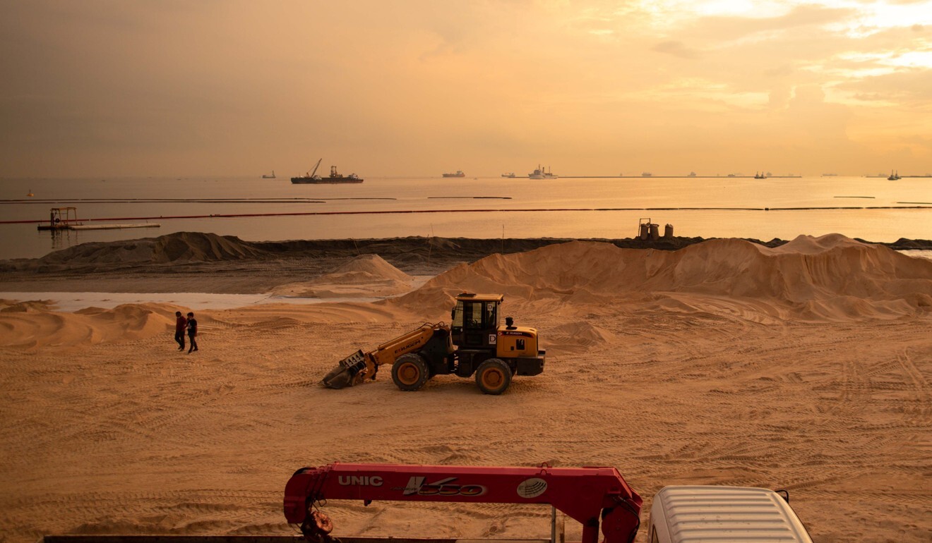 Workers walk on artificial sand made from crushed dolomite at the beach on September 10. Photo: Reuters