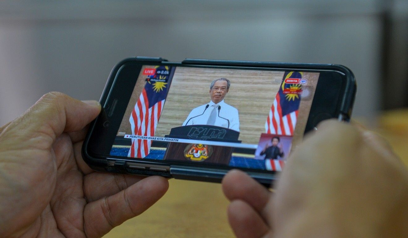 A man watches Malaysian Prime Minister Muhyiddin Yassin give a televised speech via his mobile phone at a restaurant in Kuala Lumpur earlier this month. Photo: Xinhua