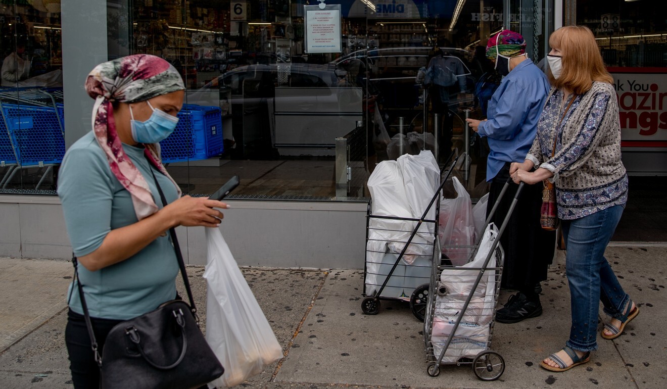 Pedestrians wear masks as they walk along down the street in the Brooklyn borough of New York on Thursday. Photo: Bloomberg