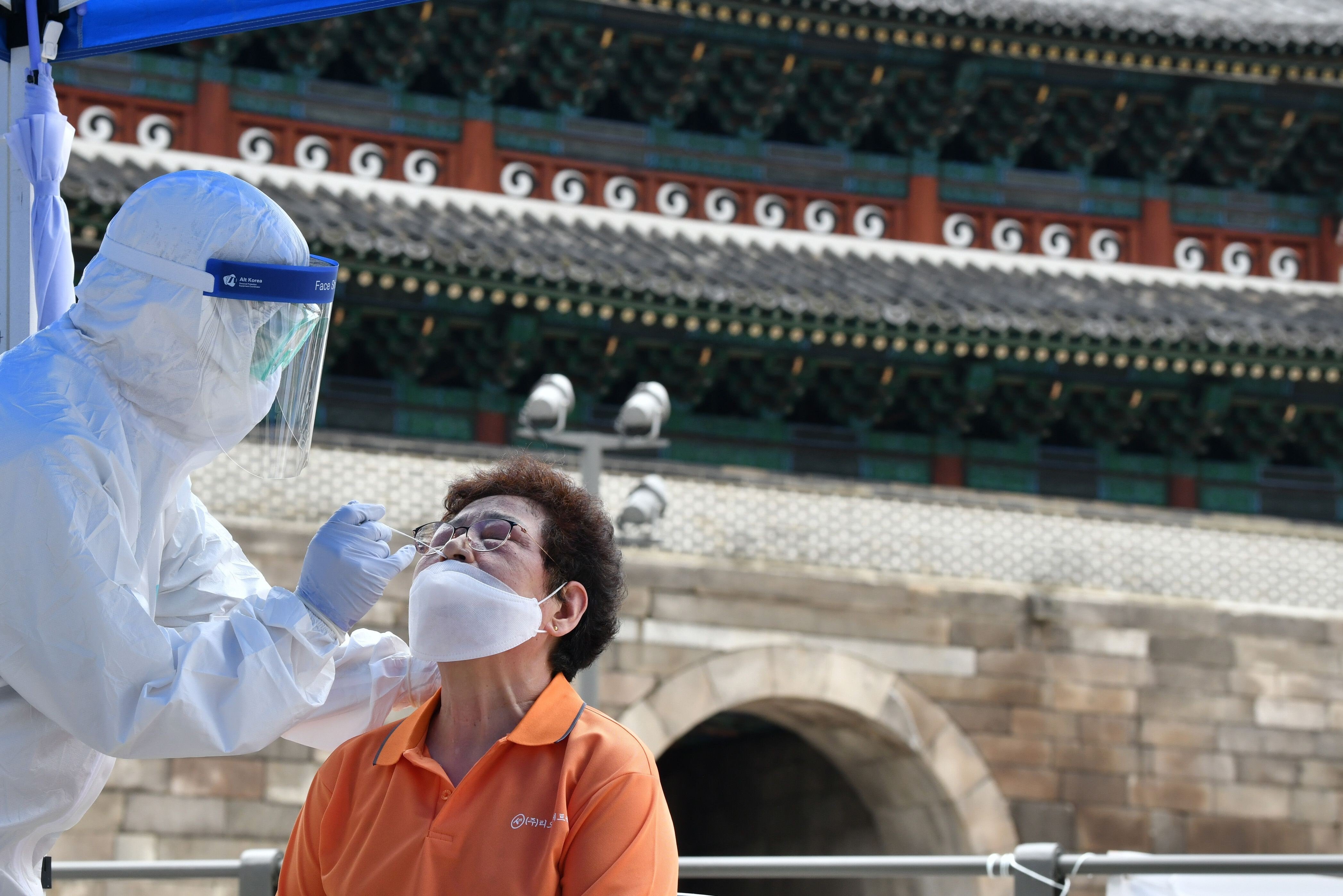 A health care worker takes test samples for the Covid-19 from a man at a temporary virus testing station near Namdaemun in Seoul on August 10. Photo: AFP