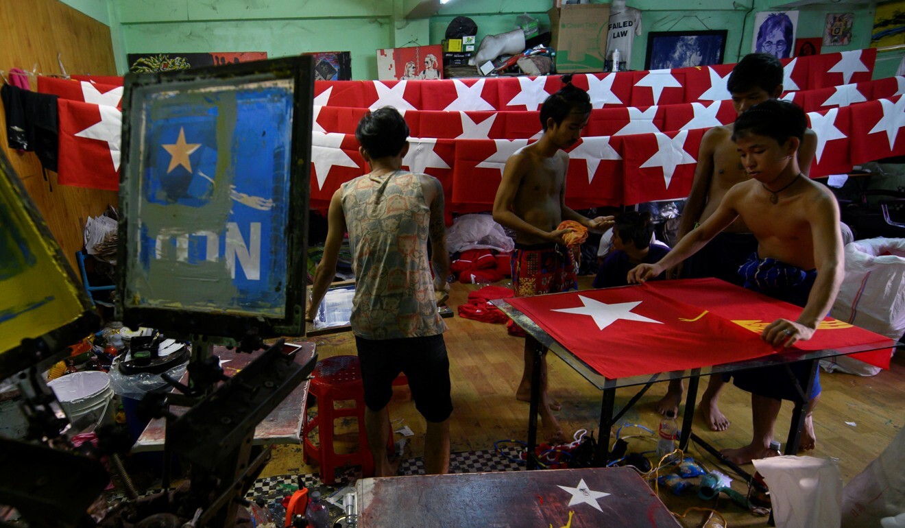 Workers print a flag with the logo of Aung San Suu Kyi’s National League for Democracy in Yangon, Myanmar. Photo: Reuters