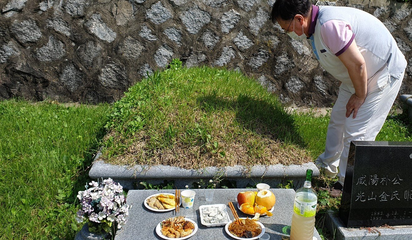Lee Kyoung-sook’s husband Chang-gyong inspects the tomb of his grandparents at a Catholic tomb in Anseong. Photo: Handout