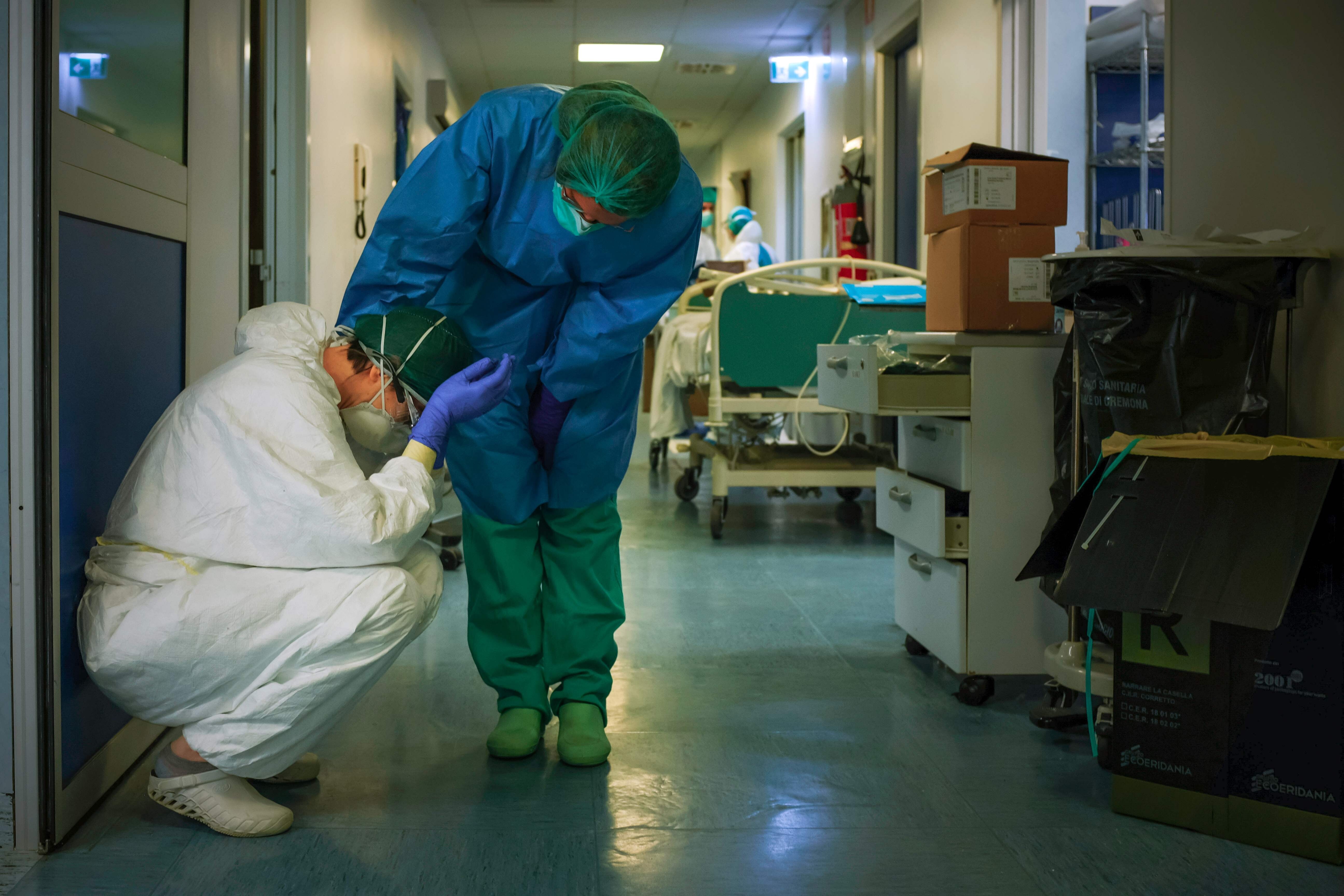 A nurse wearing protective mask and gear comforts another as they change shifts on March 13 at the Cremona hospital, southeast of Milan, during the country’s lockdown aimed at stopping the spread of the Covid-19 pandemic. Photo: AFP