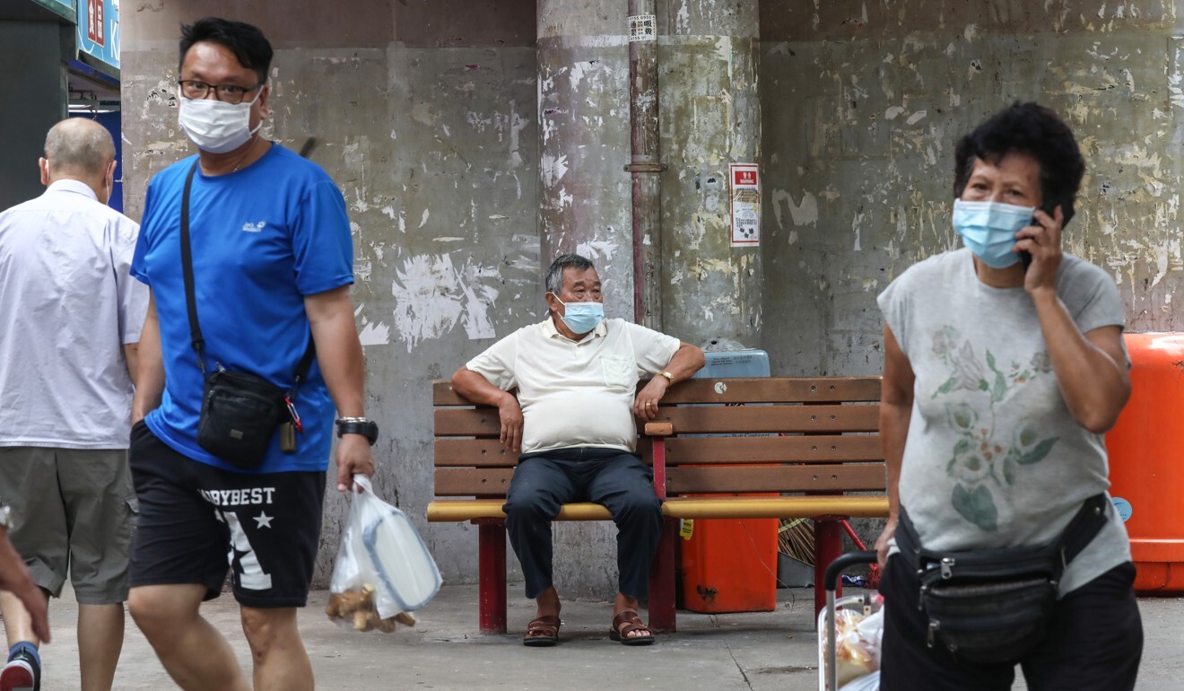 An elderly man in a face mask sits alone on a bench in Lam Tin. Photo: Jonathan Wong