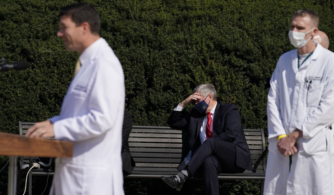 White House chief of staff Mark Meadows, centre, listens as Dr Sean Conley, doctor to US President Donald Trump, briefs reporters on Sunday. Photo: AP