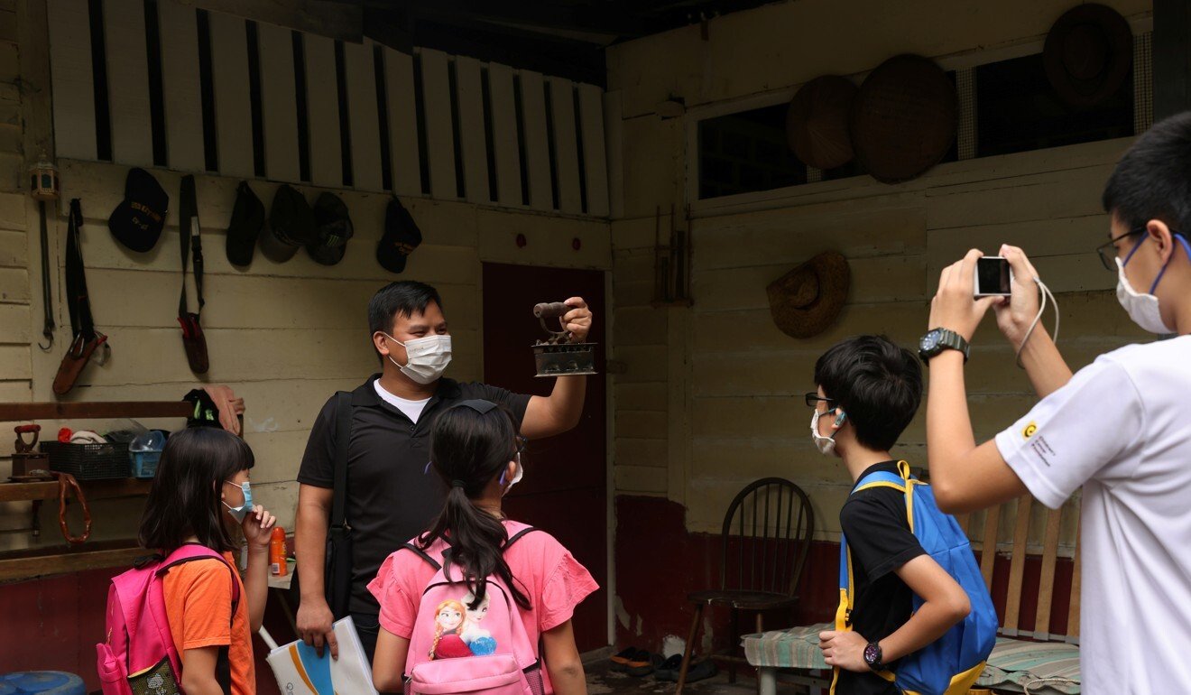 Tour guide Kyanta Yap shows a traditional coal-fired clothing iron in Kampong Lorong Buangkok. Photo: Reuters