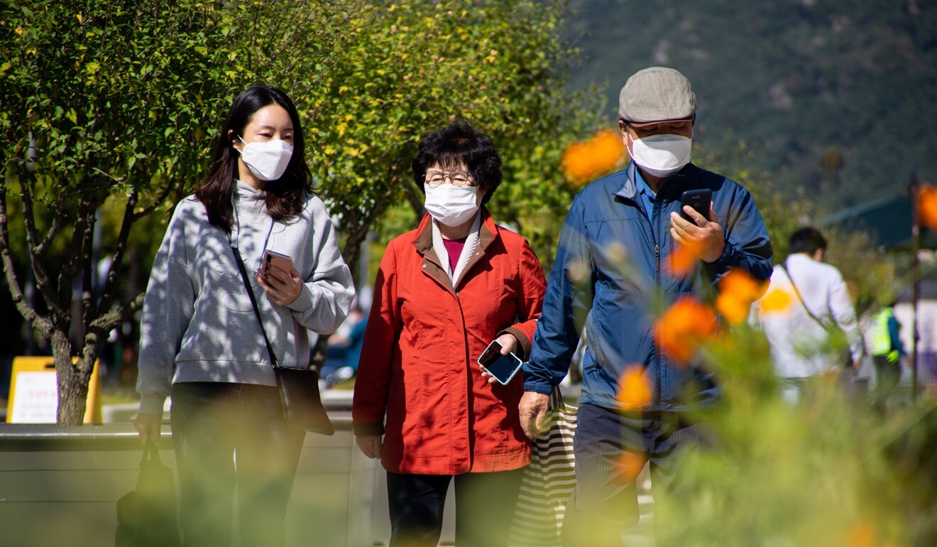 A family wearing face masks walk through Gwanghwamun Square in Seoul. Photo: EPA-EFE