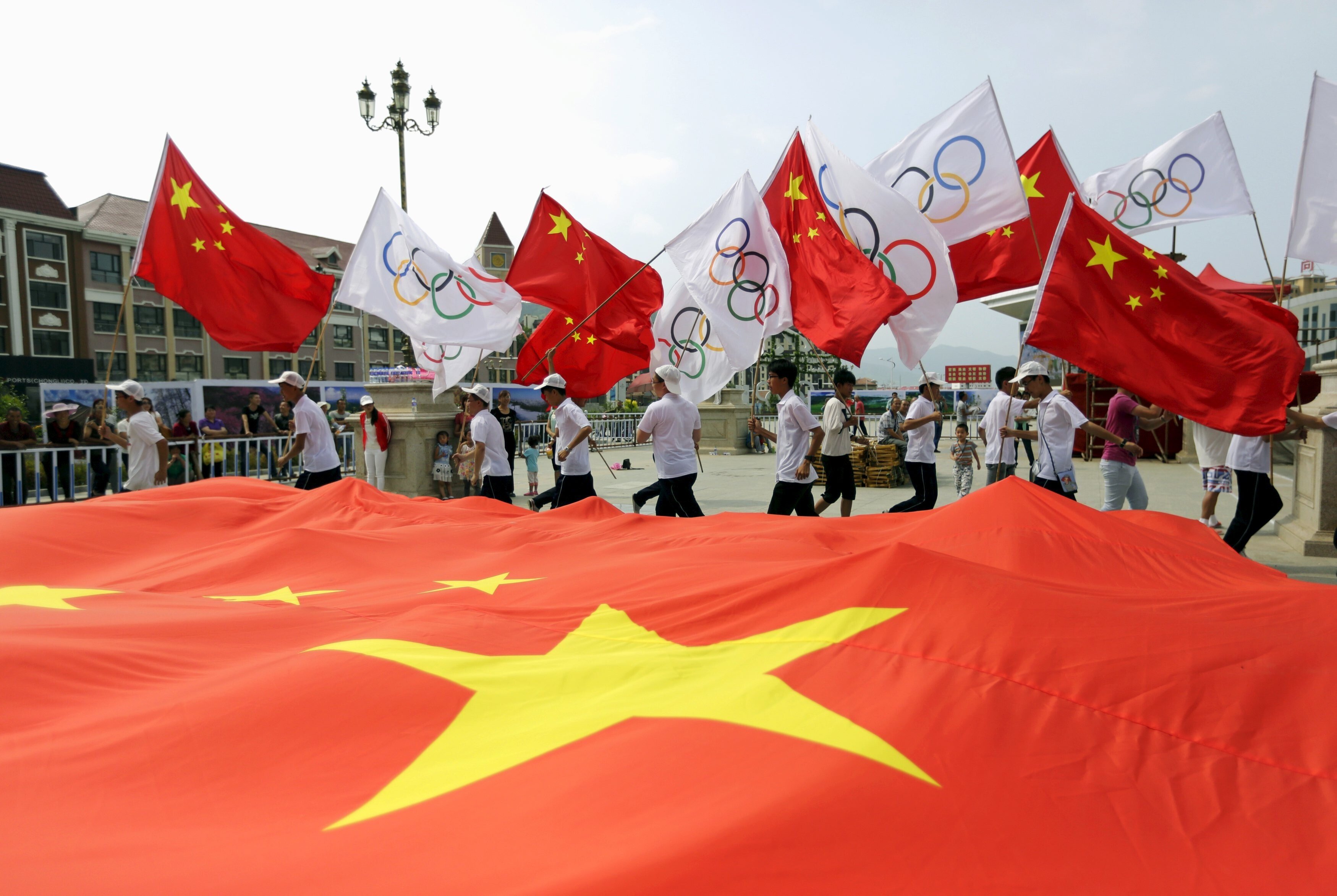 Residents hold Chinese and Olympics flags at a rehearsal for a celebration event in Zhangjiakou, which will join Beijing in hosting the 2022 Winter Olympic Games. Photo: Reuters
