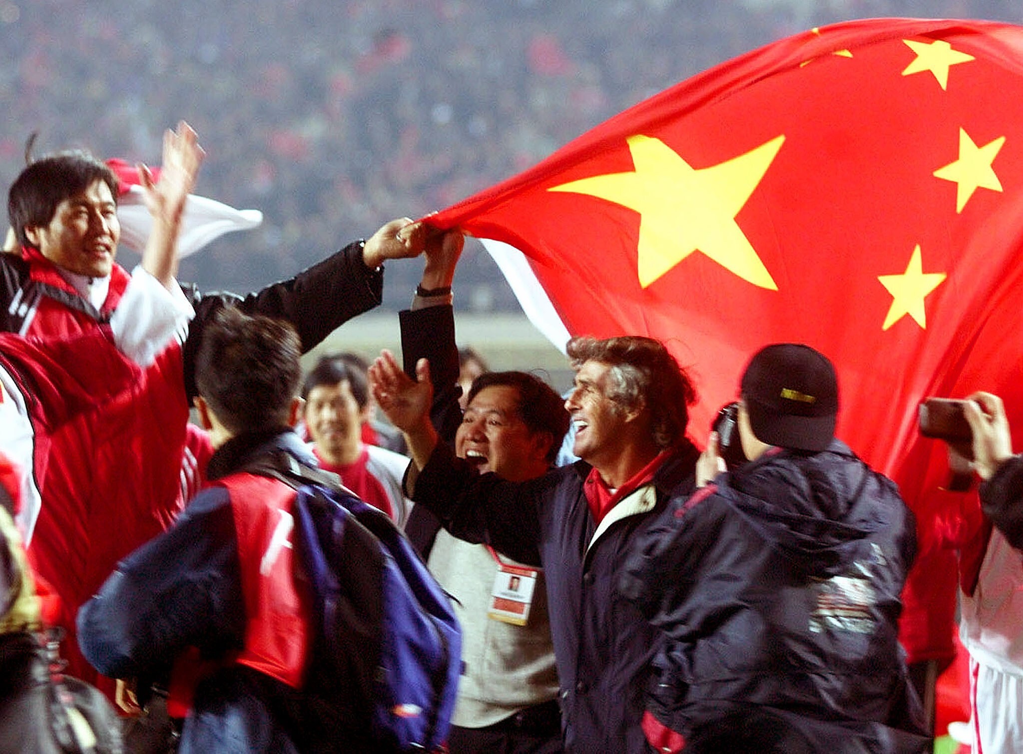 Chinese players and officials celebrate with national team coach Bora Milutinovic after China’s 1-0 victory over Oman in a crucial World Cup qualifier in Shenyang on October 7, 2001. Photo: Reuters