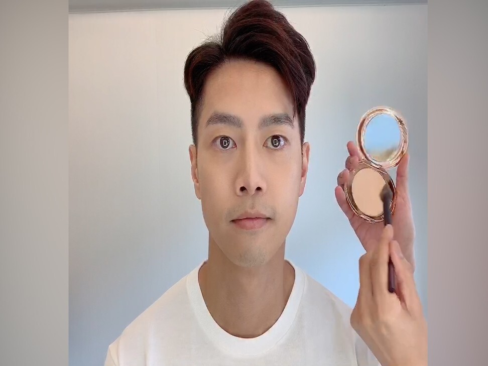 Alvin Goh applies pressed powder to Ian Choy in the final step of his make up tutorial for men.