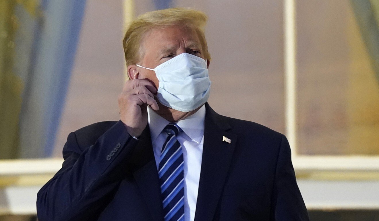 US President Donald Trump removes his mask after he returned to the White House from Walter Reed National Military Medical Center on October 5. Photo: AP