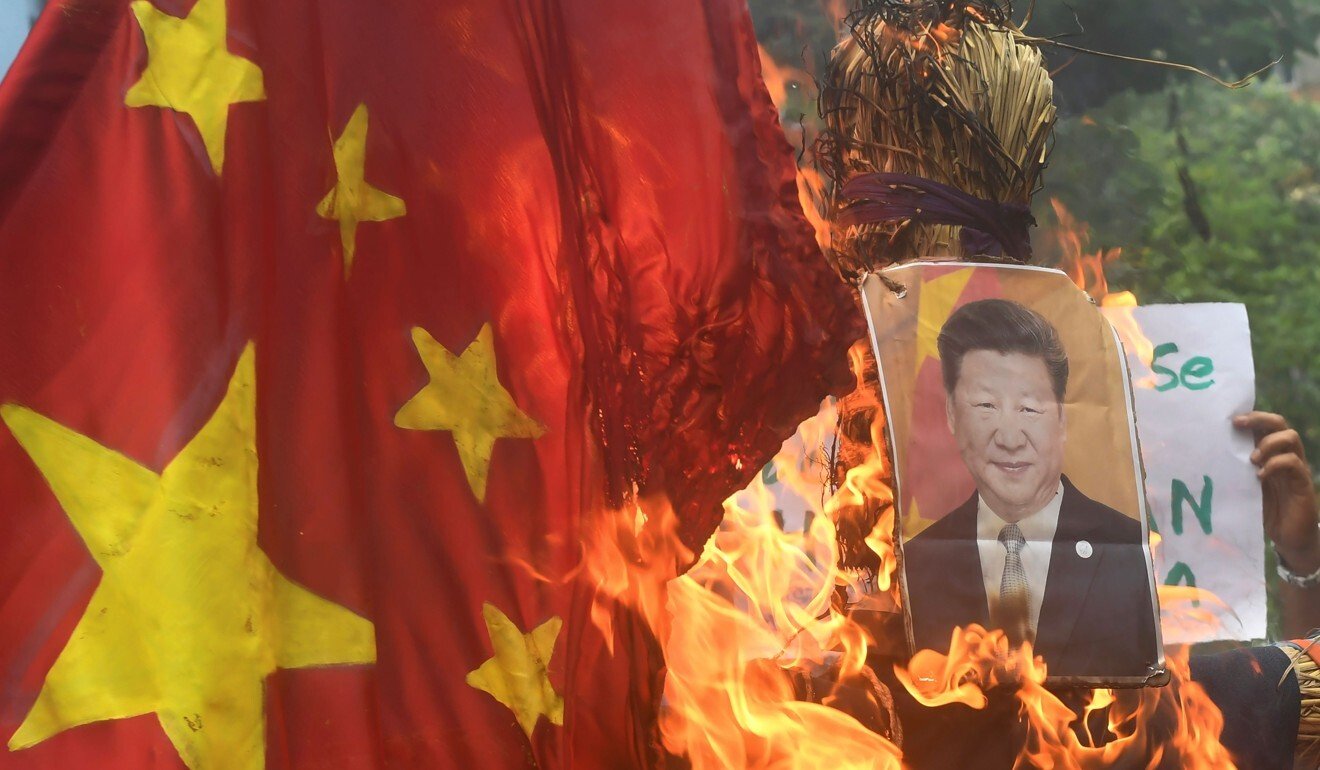 Indian protesters burn a Chinese flag and picture of Xi Jinping in a protest following a deadly clash between soldiers. Photo: AFP