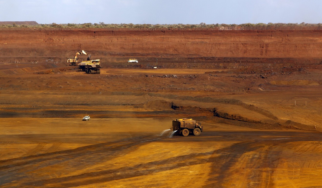 A water tanker sprays water as trucks are loaded with iron ore at the Fortescue Metals Group Christmas Creek iron ore mine located south of Port Hedland in the Pilbara region of Western Australia, in November 17, 2015. The Western Australia government forecasts growth of 1.2 per cent in 2021, fuelled by growth in the mining sector. Photo: Reuters