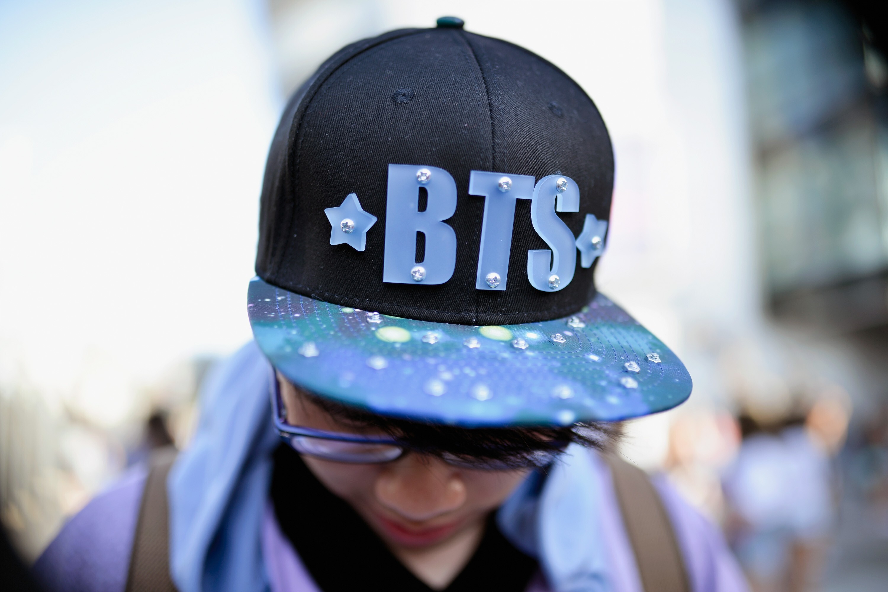 A fan, wearing a BTS hat, awaits a BTS concert. Photo: Getty Images
