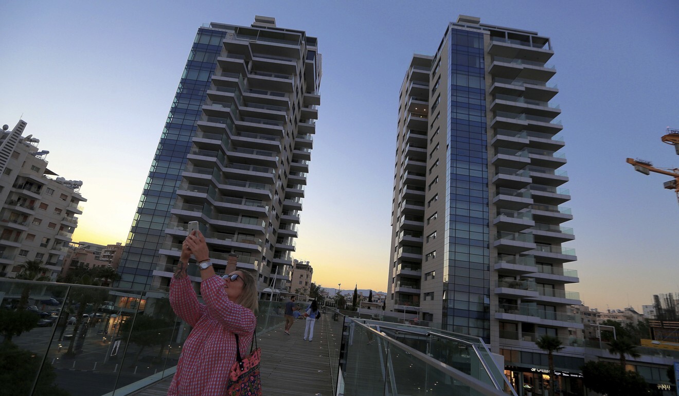 A woman takes a selfie with one of a number of new high-rises transforming the skyline view, in the southern coastal city of Limassol in the eastern Mediterranean island of Cyprus in 2018. Photo: AP