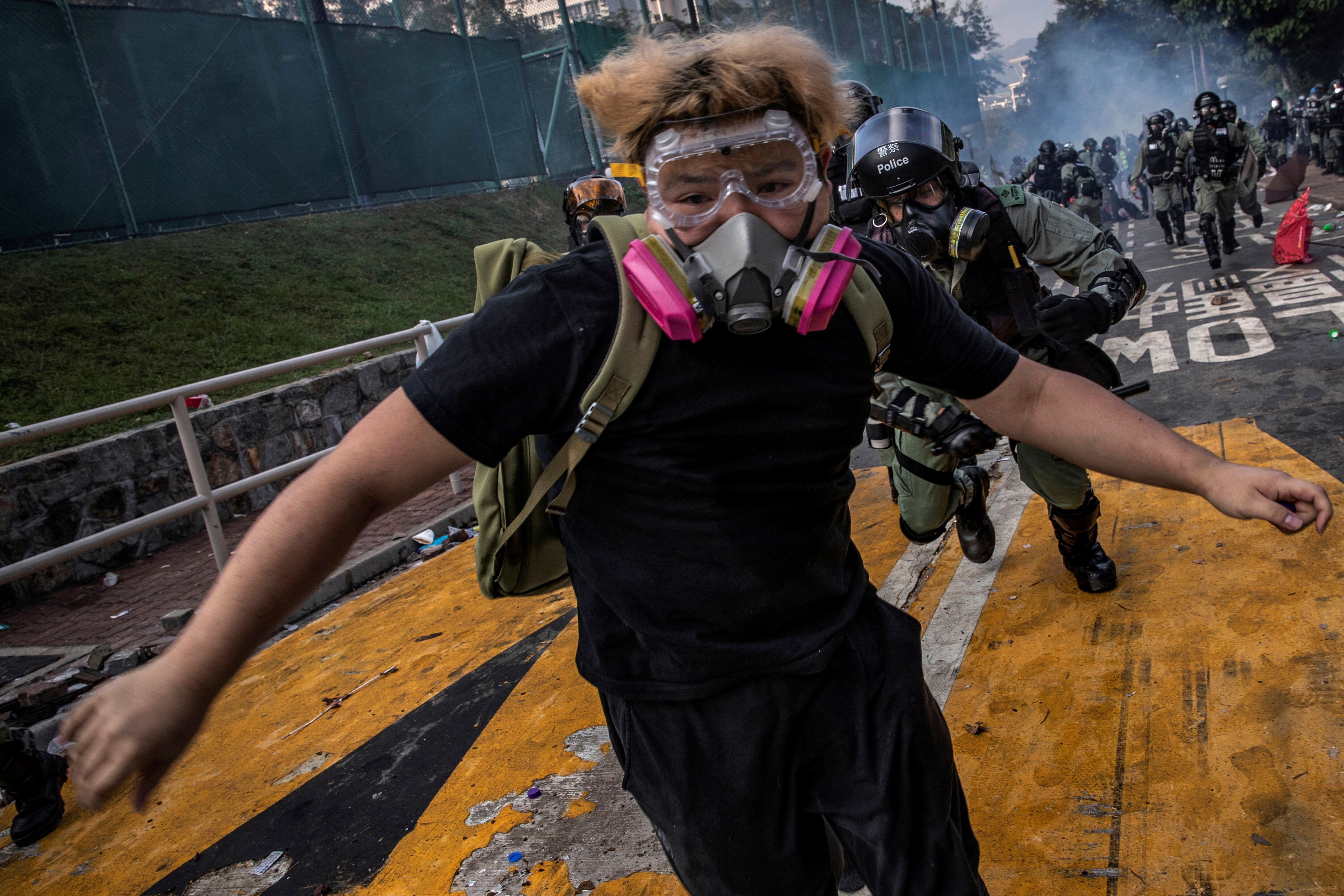 An anti-government protester is chased by riot police after skirmishes at the Chinese University of Hong Kong on November 12. Photo: Reuters