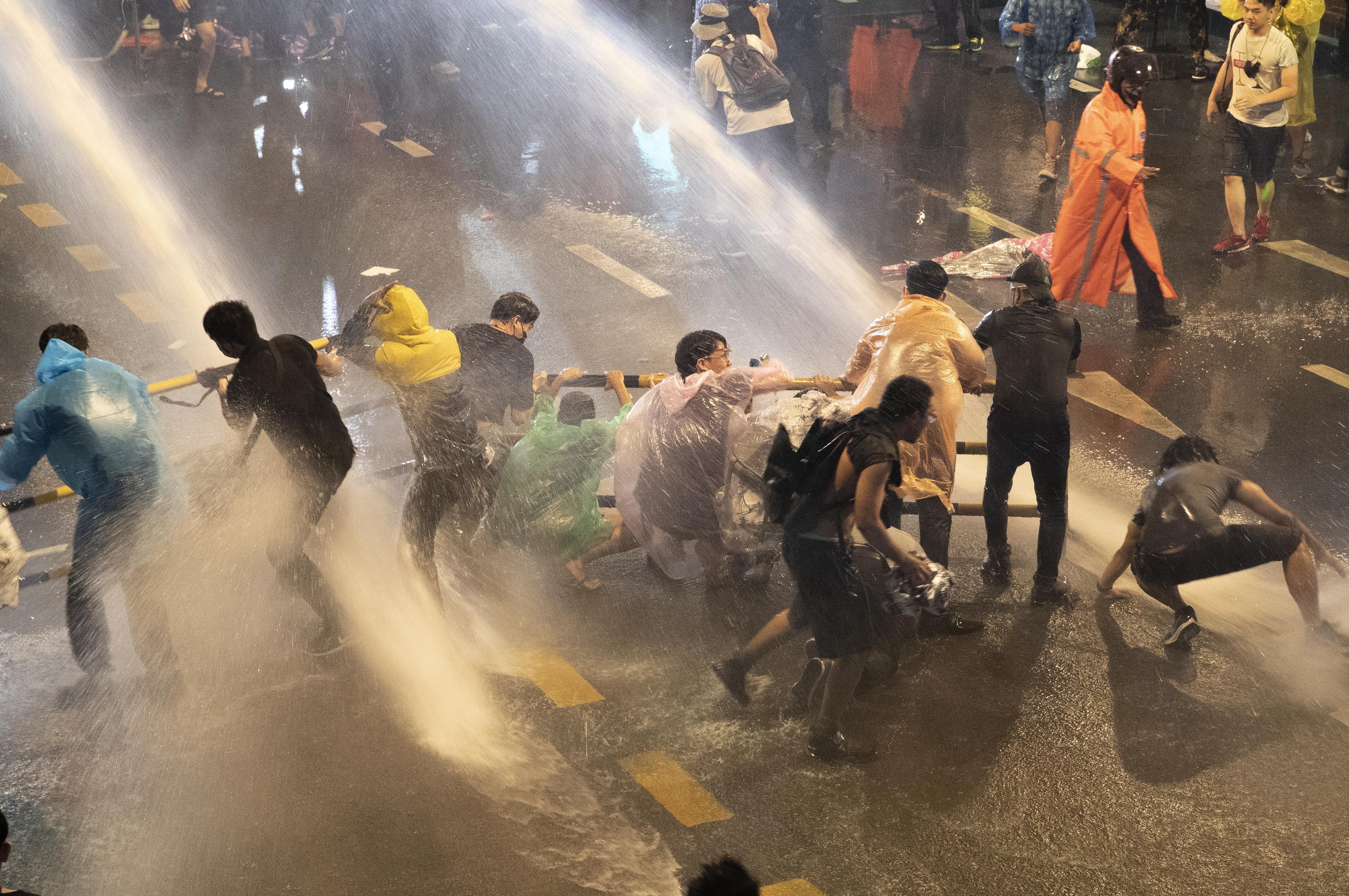 Demonstrators face water canons as police try to disperse them from their protest venue in Bangkok on Friday. Photo: AP