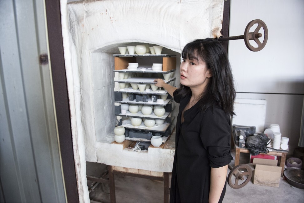 A liquid mixture of quartz, feldspar and other substances is used to seal the earthen­ware, giving it a glassy texture and rendering it waterproof. The basic glaze is a monochrome cream, but Jingdezhen is famous for its colourful porcelain made using various techniques. Zhu Simin (above), the daughter of a geologist, mixes ash from different plants to create diaphanous shades of brown and green on her delicate cups. “I’ve been studying hard to control the patterns,” she says, showing numbered triangles of china with various colours and effects. Photo: Zigor Aldama