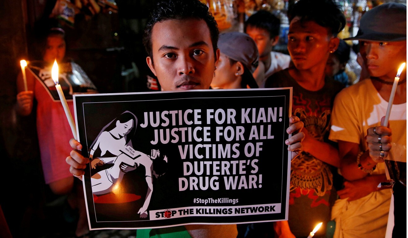Protesters hold candles at the wake of Kian delos Santos, a 17-year-old high school student, who was killed in the war on drugs in 2017. Photo: Reuters
