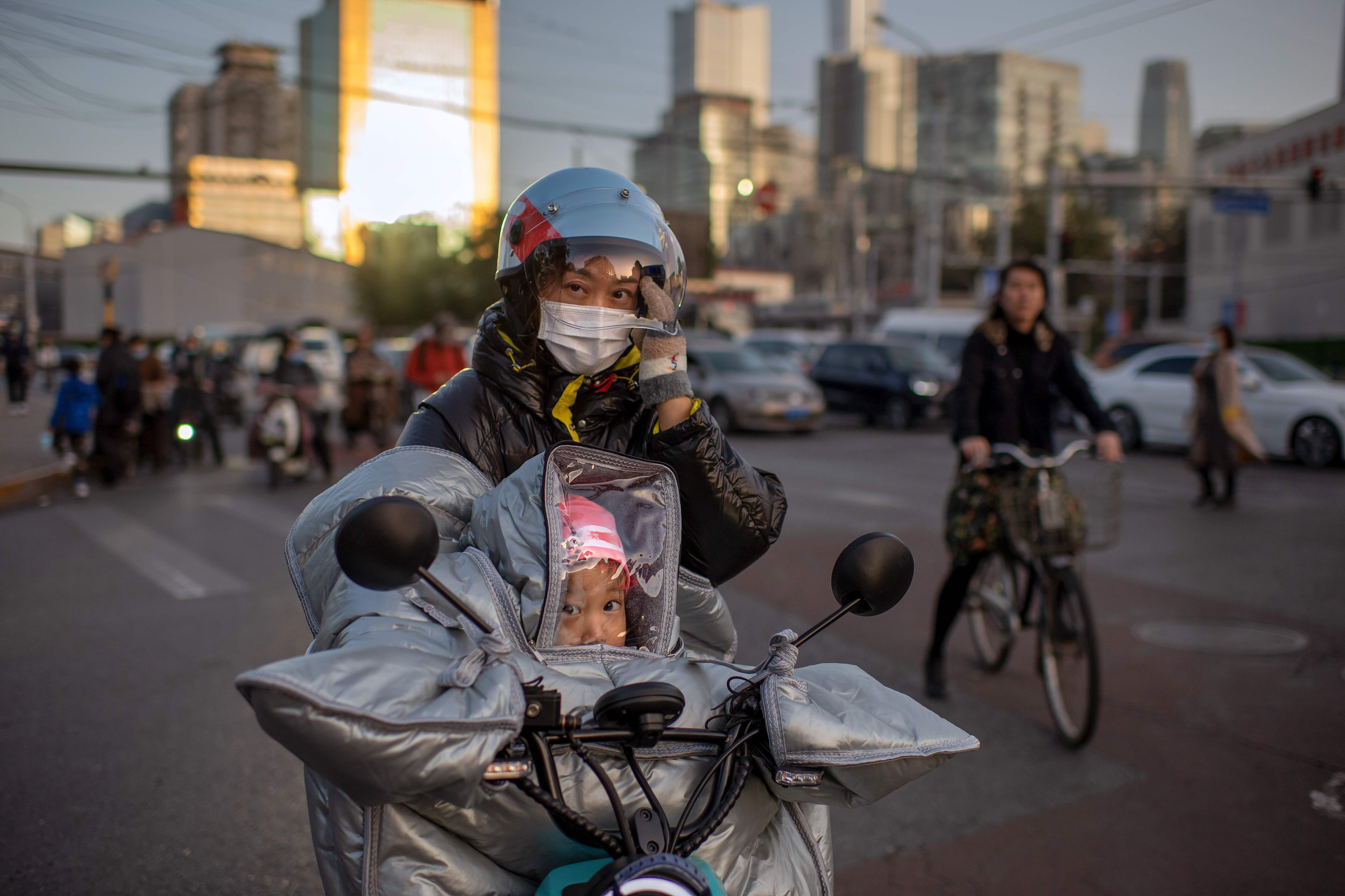 A woman and a child in protective gear ride an electric bike during rush hour in Beijing. China’s recovery from the pandemic has not eliminated the uncertainties surrounding its growth outlook. Photo: AFP