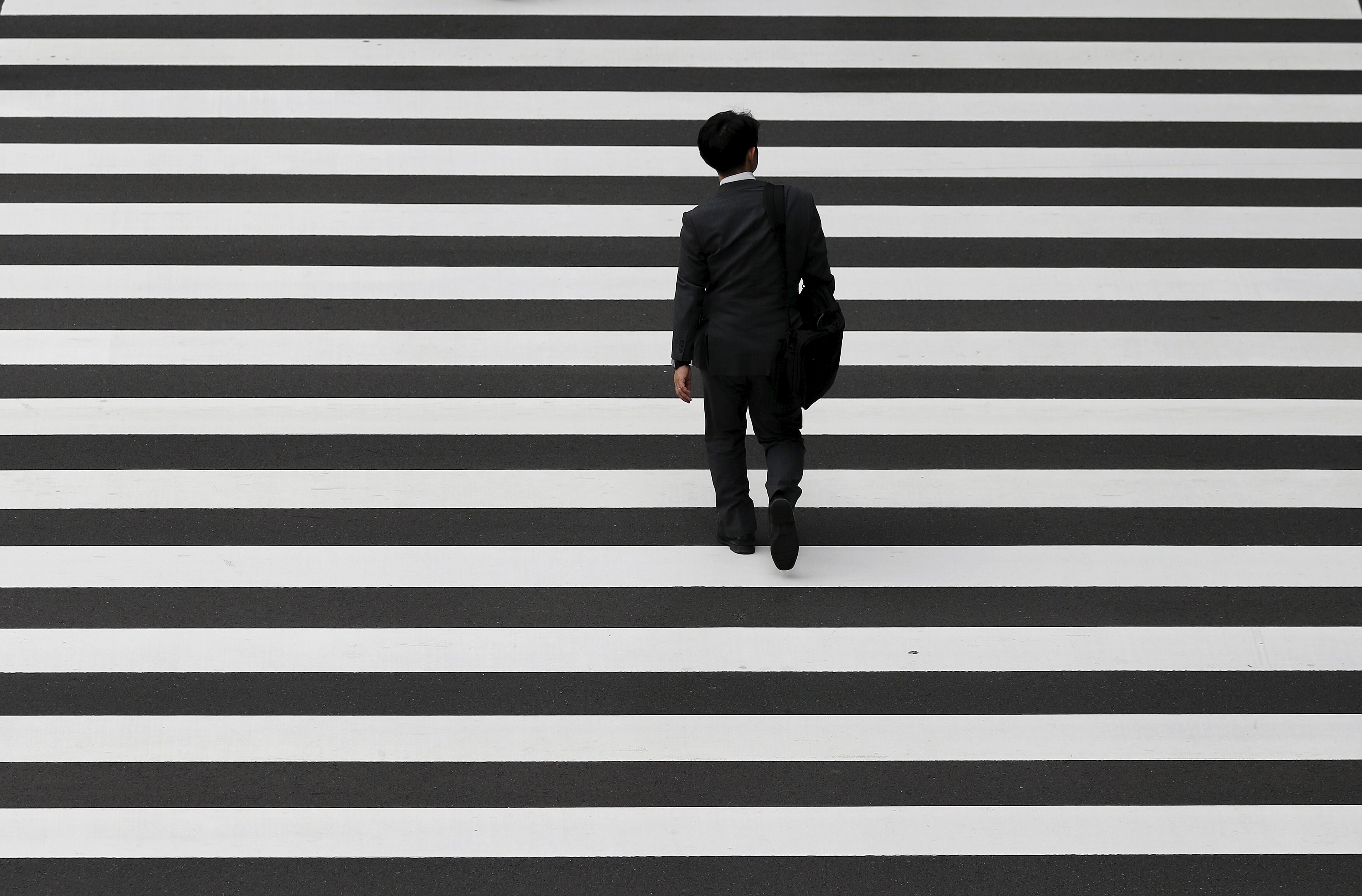 A businessman crosses a road in Tokyo’s business district in October 2015. Since the early 1990s, Japan has battled deflation. Photo: Reuters