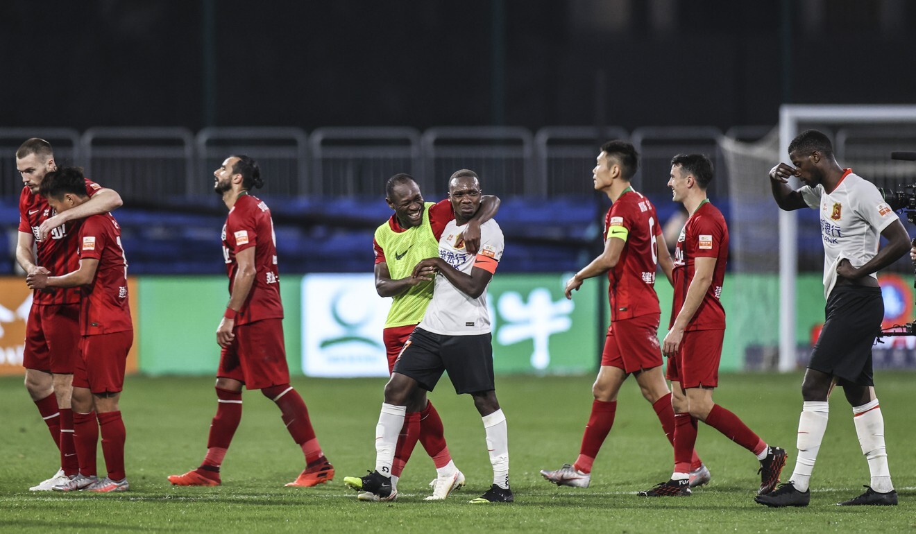 Jean Evrard Kouassi (centre) of Wuhan Zall is embraced by Christian Bassogog of Henan Jianye after their CSL match in October. Photo: Xinhua