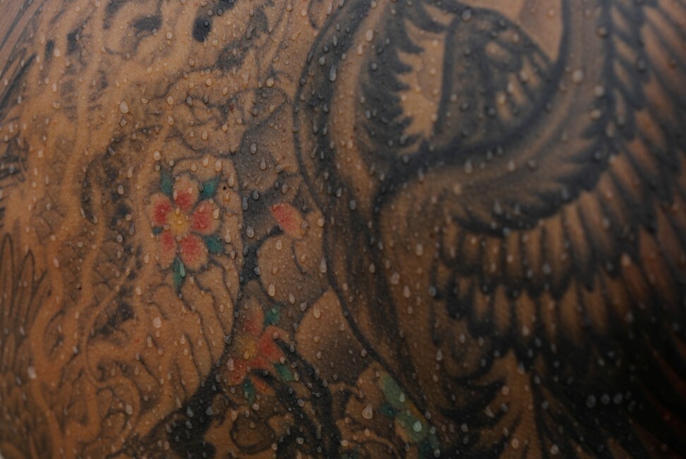 Surfer and TV set designer Takashi Mikajiri, 42, shows his back tattoos on the beach after surfing in Chiba prefecture, Japan. Photo: Reuters/Kim Kyung-Hoon