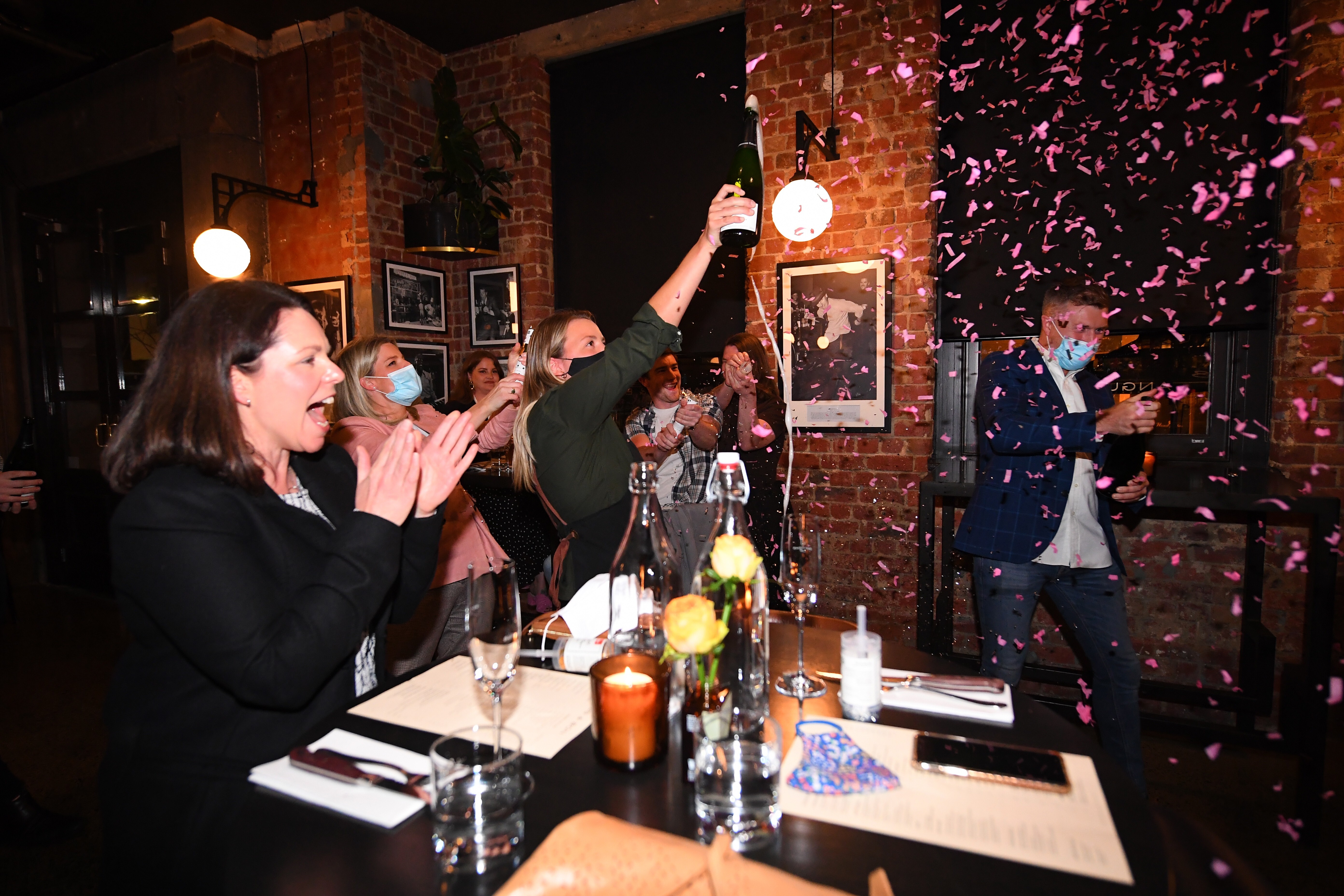 Patrons and staff celebrate the end of Melbourne’s coronavirus lockdown at a steakhouse on Wednesday. Photo: EPA