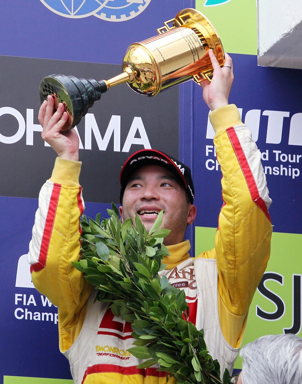 Darryl O'Young celebrates with a trophy after winning his class and finishing fifth at the 2012 WTCC FIA World Touring Car Champion final in Macau. Photo: Nora Tam