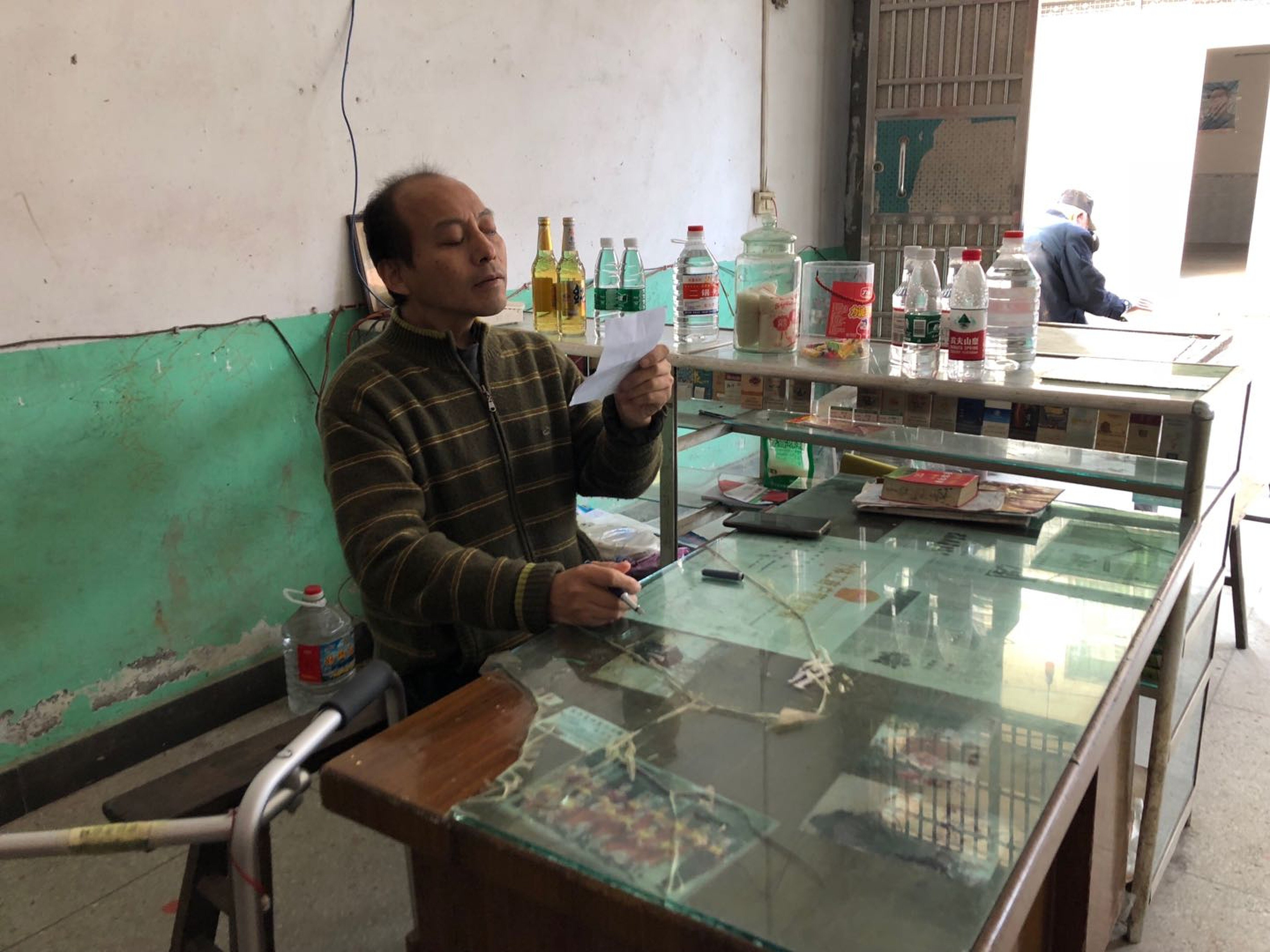 After four surgeries and months of rehabilitation, “folded man” Li Hua is able to run a small stand selling tobacco and alcohol. Photo: Alice Yan