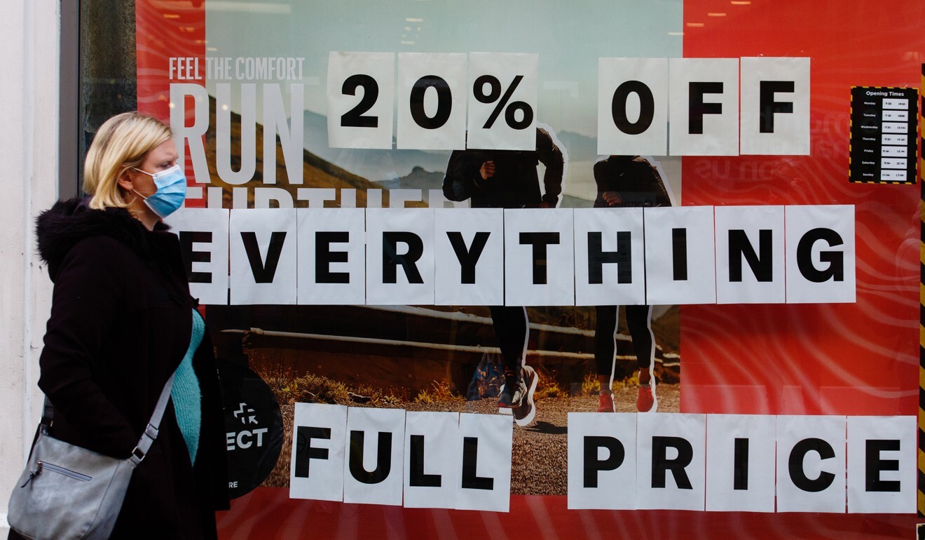 A shopper passes sale signs in the window of a Sports Direct store in Canterbury, UK, on November 3. UK retailers face a Christmas disaster after the government ordered non-essential stores across England to shut for four weeks just as the busiest shopping season of the year was getting under way. Photo: Bloomberg
