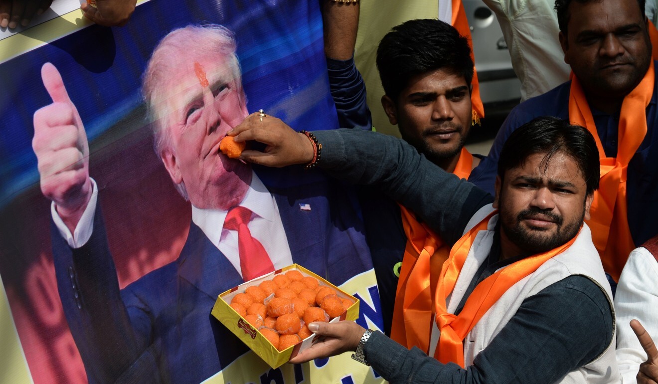Right-wing activists of India's Hindu Sena offer sweets to a poster of Donald Trump in 2016. Can their support swing things for him again? Photo: AFP