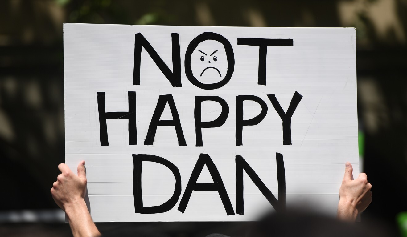 A protester holds up a sign criticising Victorian Premier Daniel Andrews. Photo: EPA