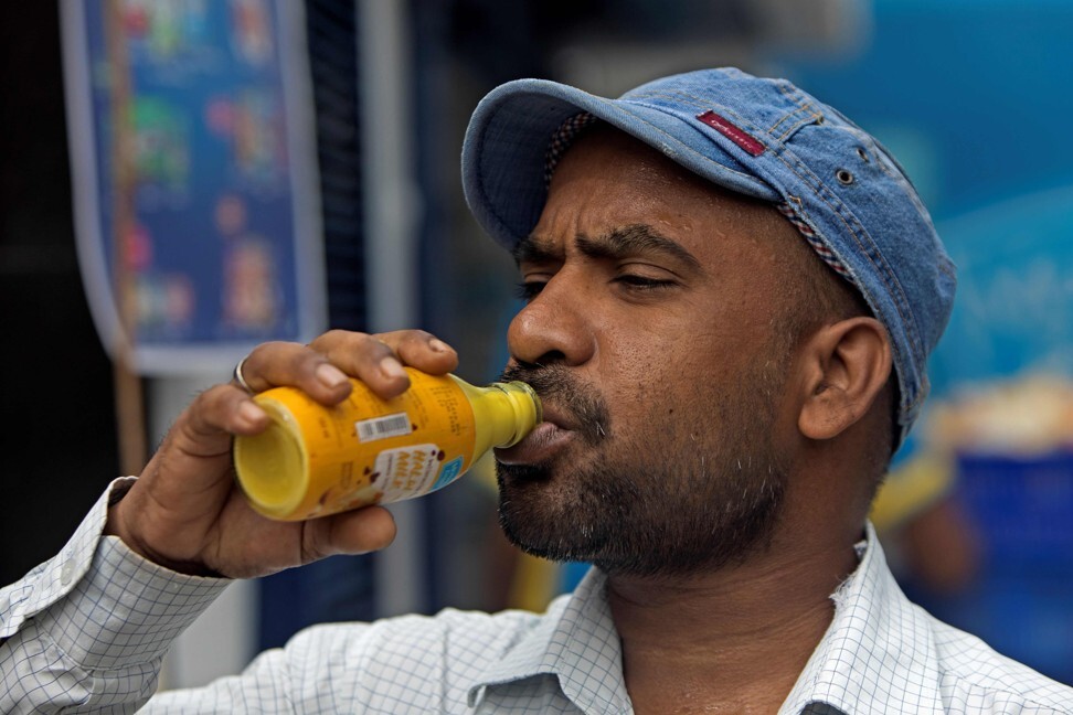 A man drinks a turmeric milk drink. The spice is believed to have immunity-boosting qualities. Photo: AFP