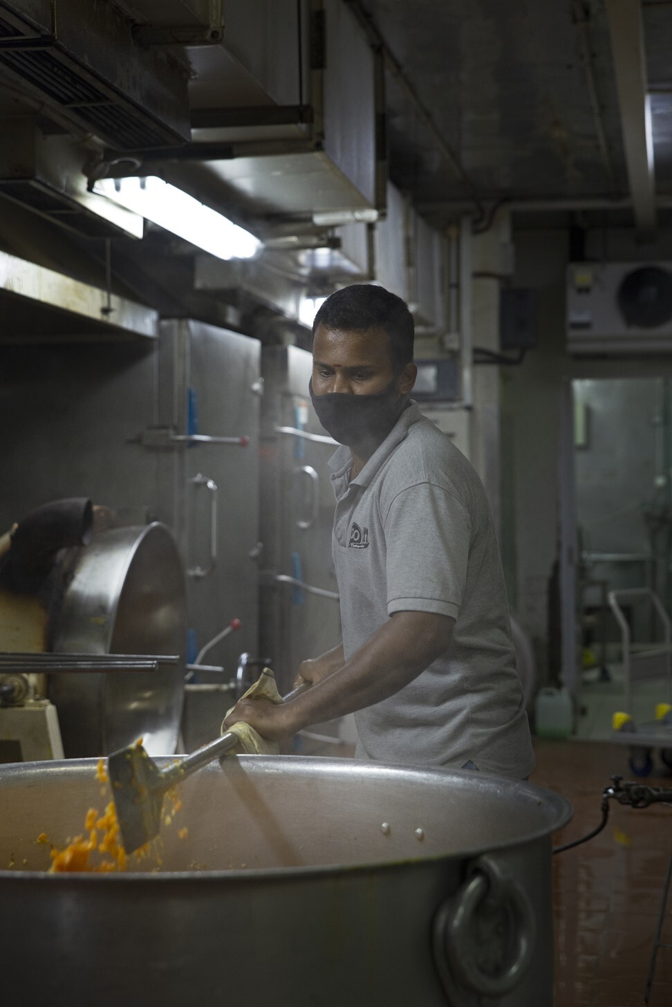 A cook mixes a pot of carrots, dal and masala flavouring for the day’s Indian menu. Photo: Olyvia Lim