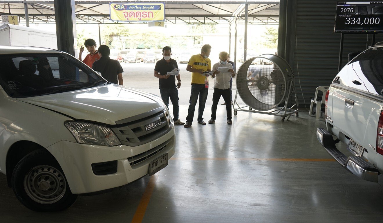 Potential buyers assess lists of second-hand cars at the SIA warehouse. Photo: Vijitra Duangdee