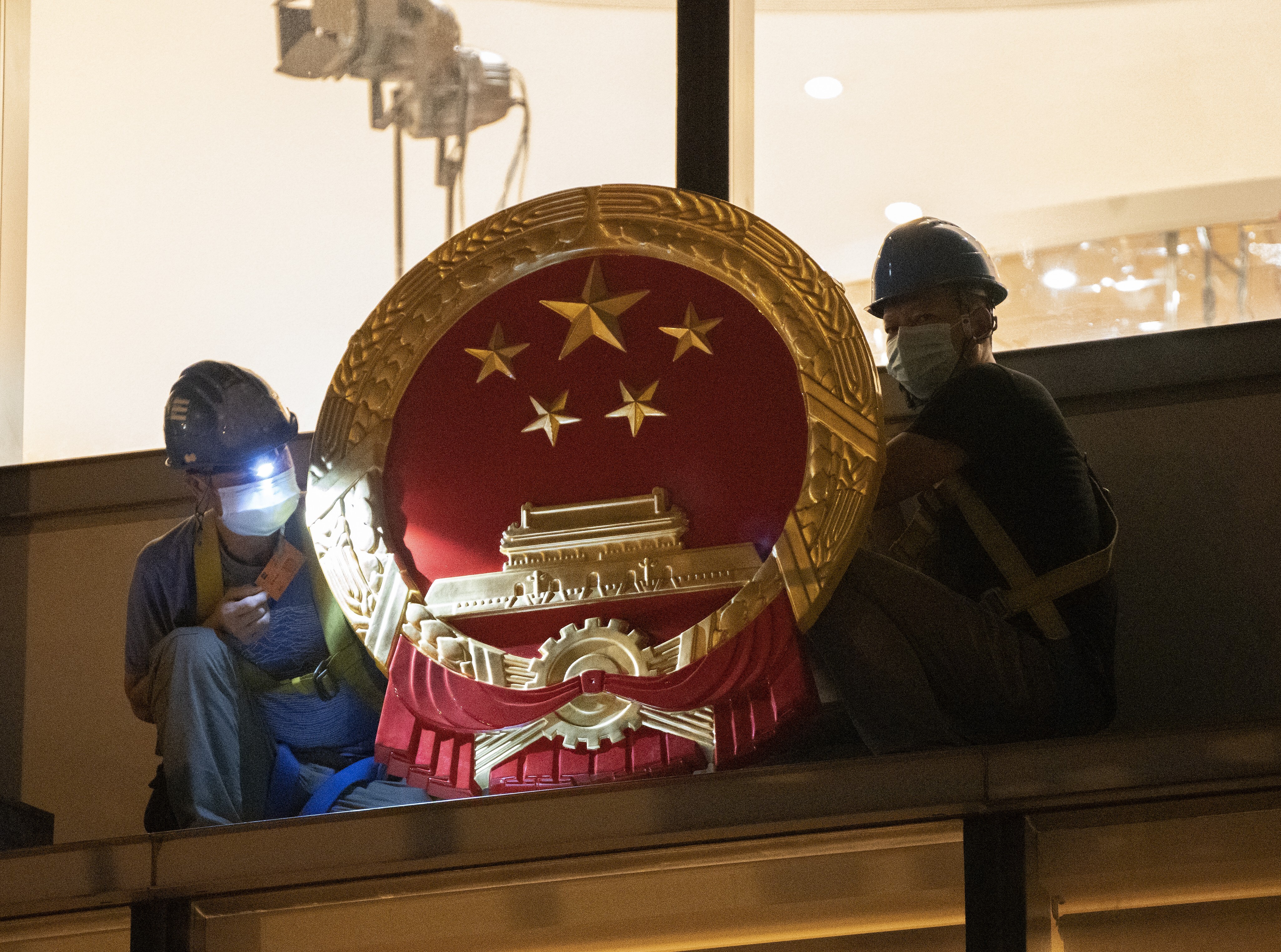 Workers place a national emblem outside the Metropark Hotel in Causeway, as the four-star property became the new temporary headquarters of the Office for Safeguarding National Security, on July 8. Photo: Robert Ng