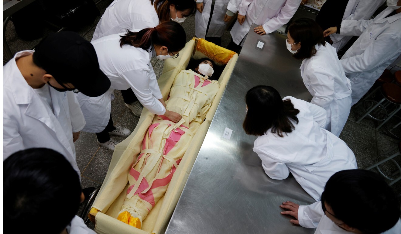 A student is laid in a mock coffin during a class on how to shroud a body. Photo: Reuters