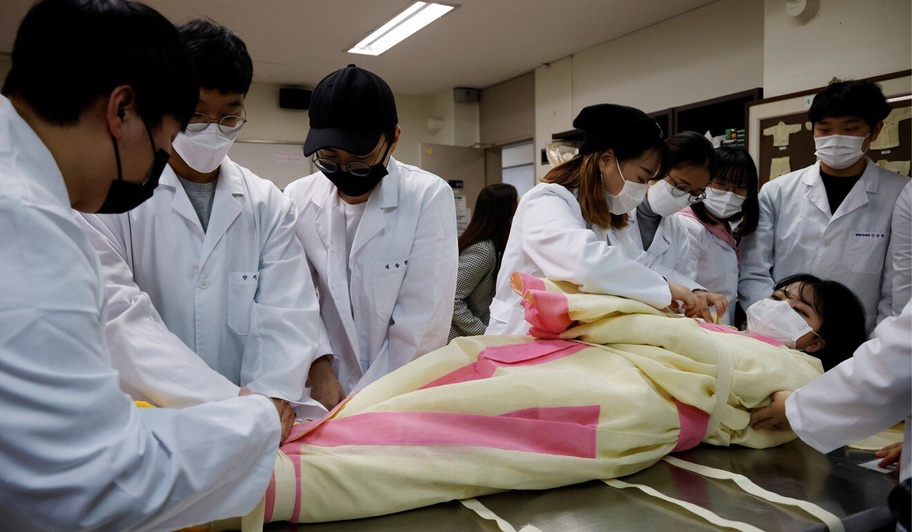 Park Se-jung who majors the funeral directing at Eulji University, volunteers to be used as a corpse in a demonstration of how to shroud the deceased. Photo: Reuters