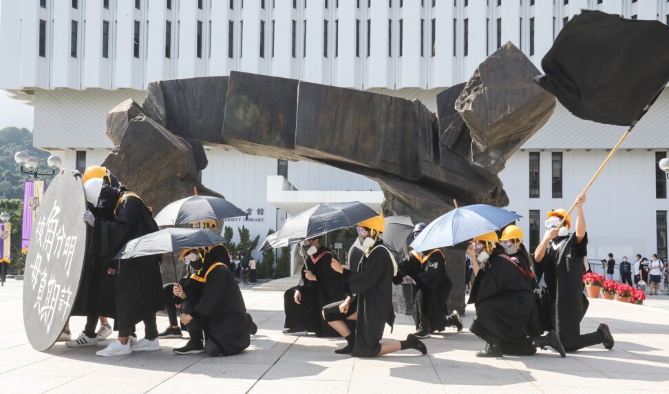 Dressed in graduation gowns, and some wearing the yellow hard hats popular during last year’s protests, former students attend a demonstration at CUHK. Photo: K. Y. Cheng