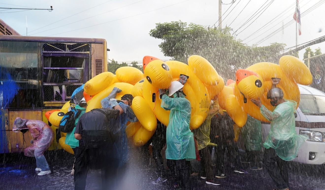 Demonstrators use inflatable rubber ducks as shields to protect themselves from water cannons. Photo: Reuters