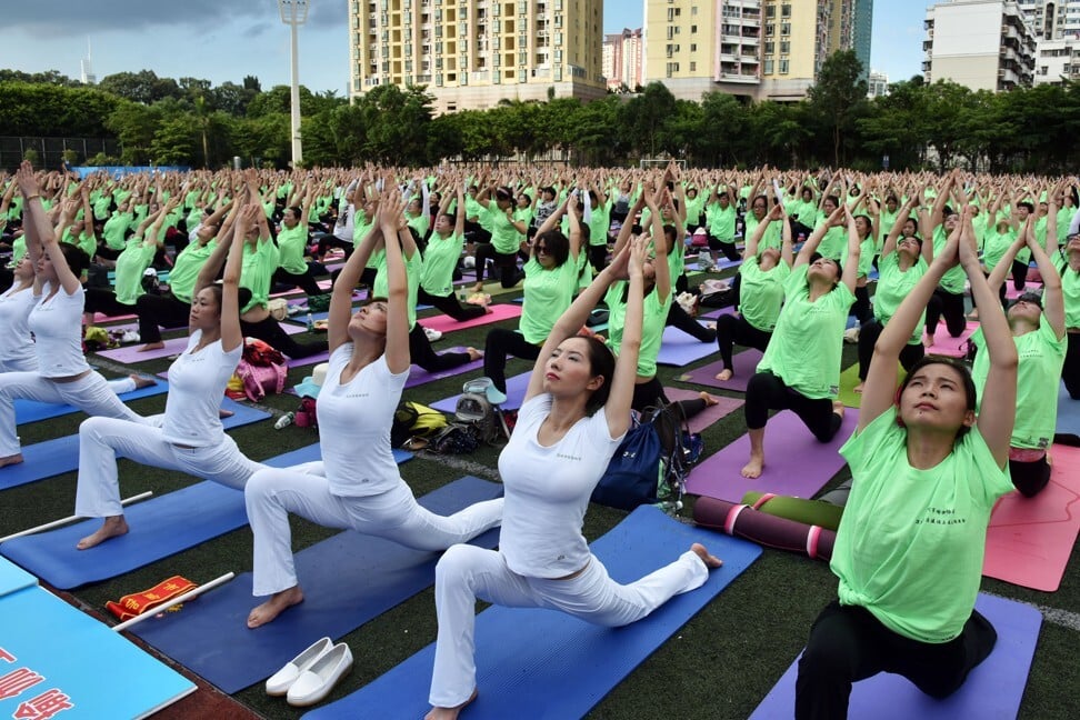 Enthusiasts practice yoga in Shenzhen. Authorities plan to improve living standards by ensuring the health of citizens. Photo: AFP