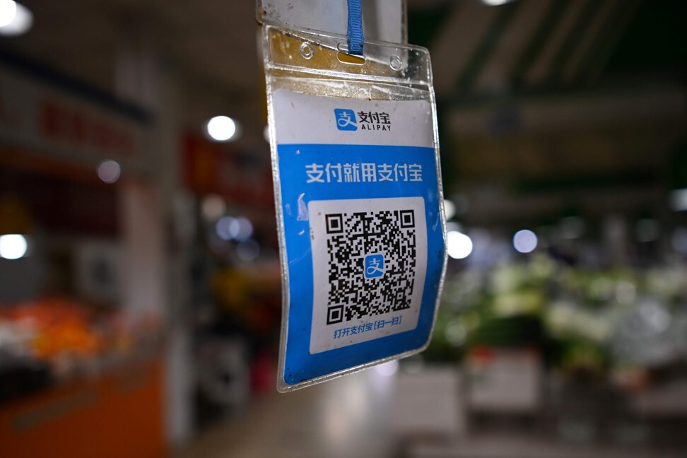 A QR payment code for Ant’s Alipay hangs above a stall for customers to scan with their smartphones to make electronic payments at a market in Beijing. Photo: AFP
