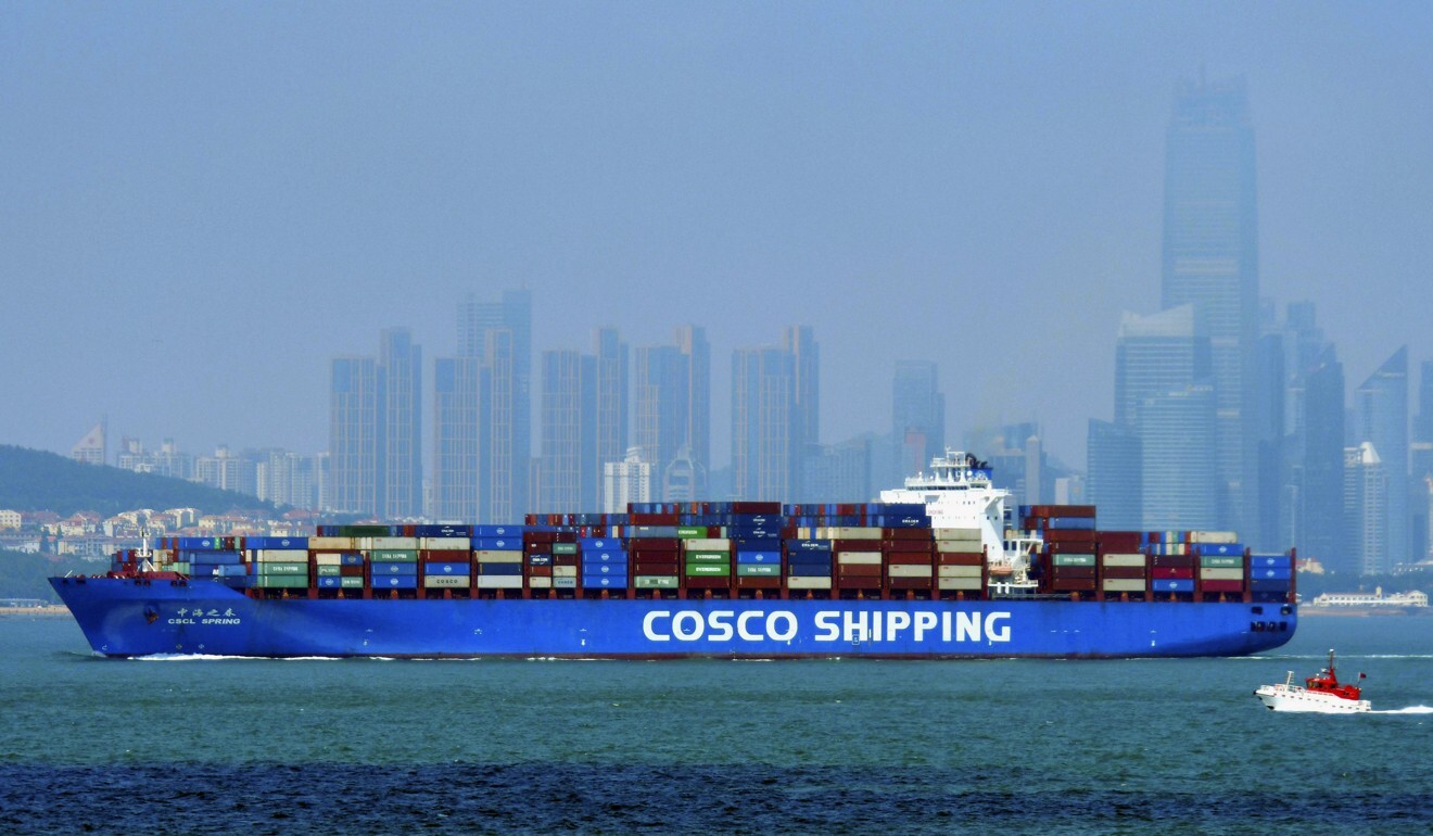 A Cosco Shipping container ship sails past the skyline of Qingdao in eastern China's Shandong province in July. Photo: AP