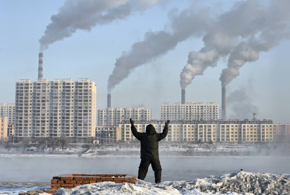 A man doing his morning exercises in front of chimney stacks across the Songhua River in Jilin province on February 24, 2013. Photo: Reuters